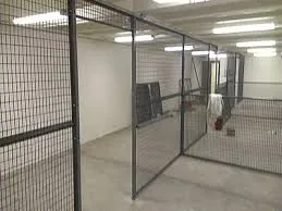 A row of caged storage rooms with mesh walls and lockable doors